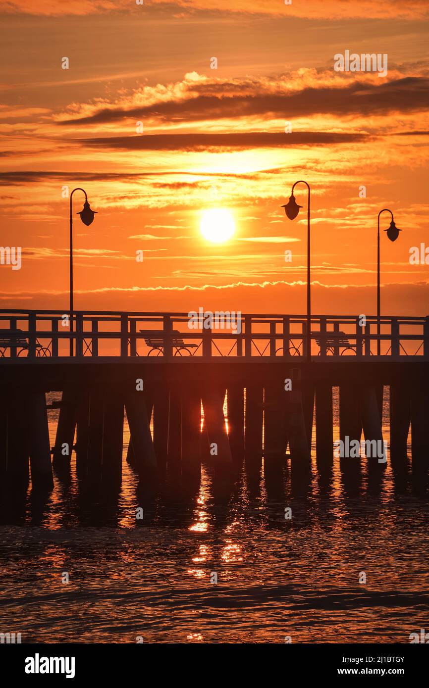 Traumhafter Sonnenaufgang über der polnischen Küste. Wunderschöne Morgensonne über dem Pier in Gdynia, Polen. Stockfoto