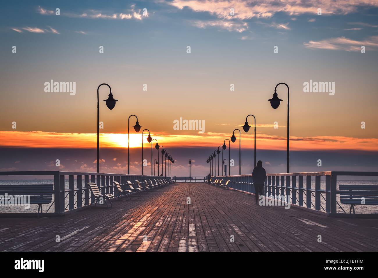 Wunderschöne Landschaft am Morgen am Meer. Hölzerner Pier mit einem bunten Himmel in Gdynia Orlowo, Polen. Stockfoto