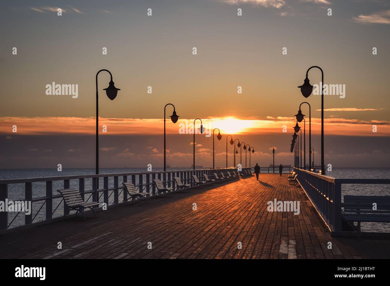 Wunderschöne Landschaft am Morgen am Meer. Hölzerner Pier mit einem bunten Himmel in Gdynia Orlowo, Polen. Stockfoto