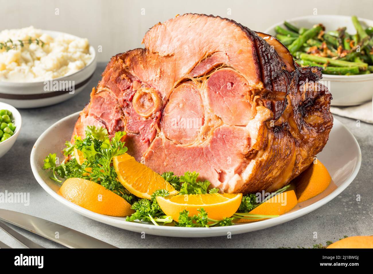 Hausgemachtes Oster-Schinken-Abendessen mit Pototoebohnen und Erbsen Stockfoto