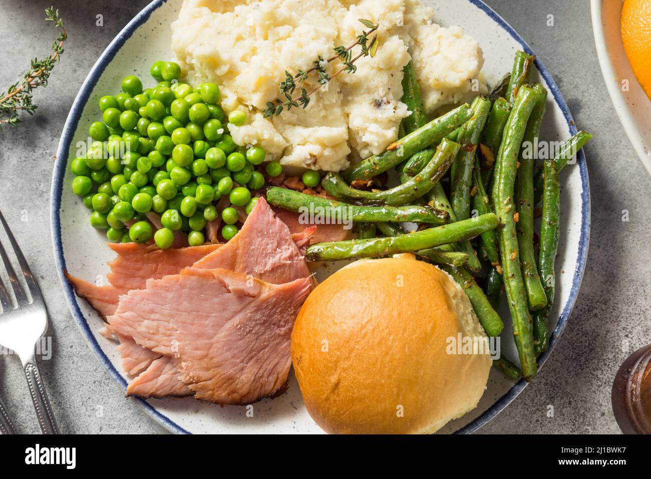 Hausgemachtes Oster-Schinken-Abendessen mit Pototoebohnen und Erbsen Stockfoto
