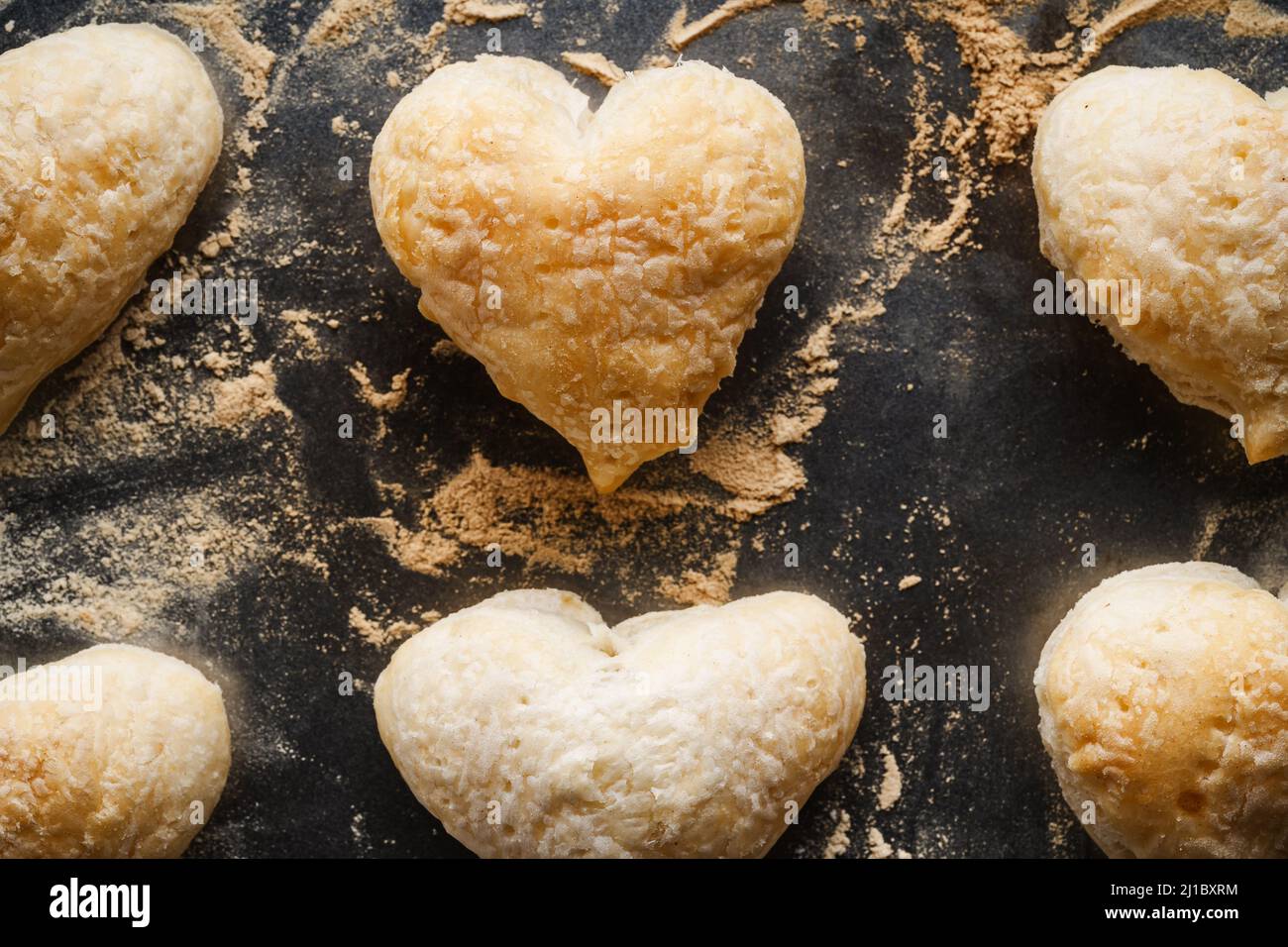 Blätterteig herzförmige Plätzchen auf Backblech, Draufsicht. Backen Valentinstag hausgemachtes Dessert Stockfoto