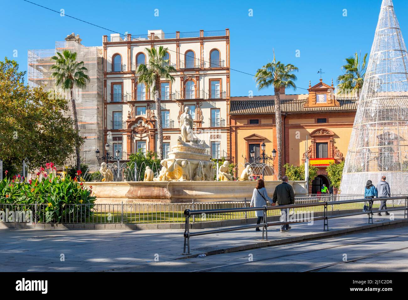Nicht identifizierbare Edestrians passieren den Brunnen von Sevilla auf dem Puerta de Jerez Platz im historischen Zentrum von Sevilla, Spanien. Stockfoto