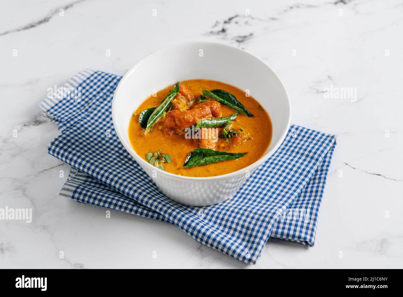 Goan Fish Curry Masala in einem Gericht isoliert auf Serviette Seitenansicht auf grauem Hintergrund berühmten indischen und pakistanischen Essen Stockfoto