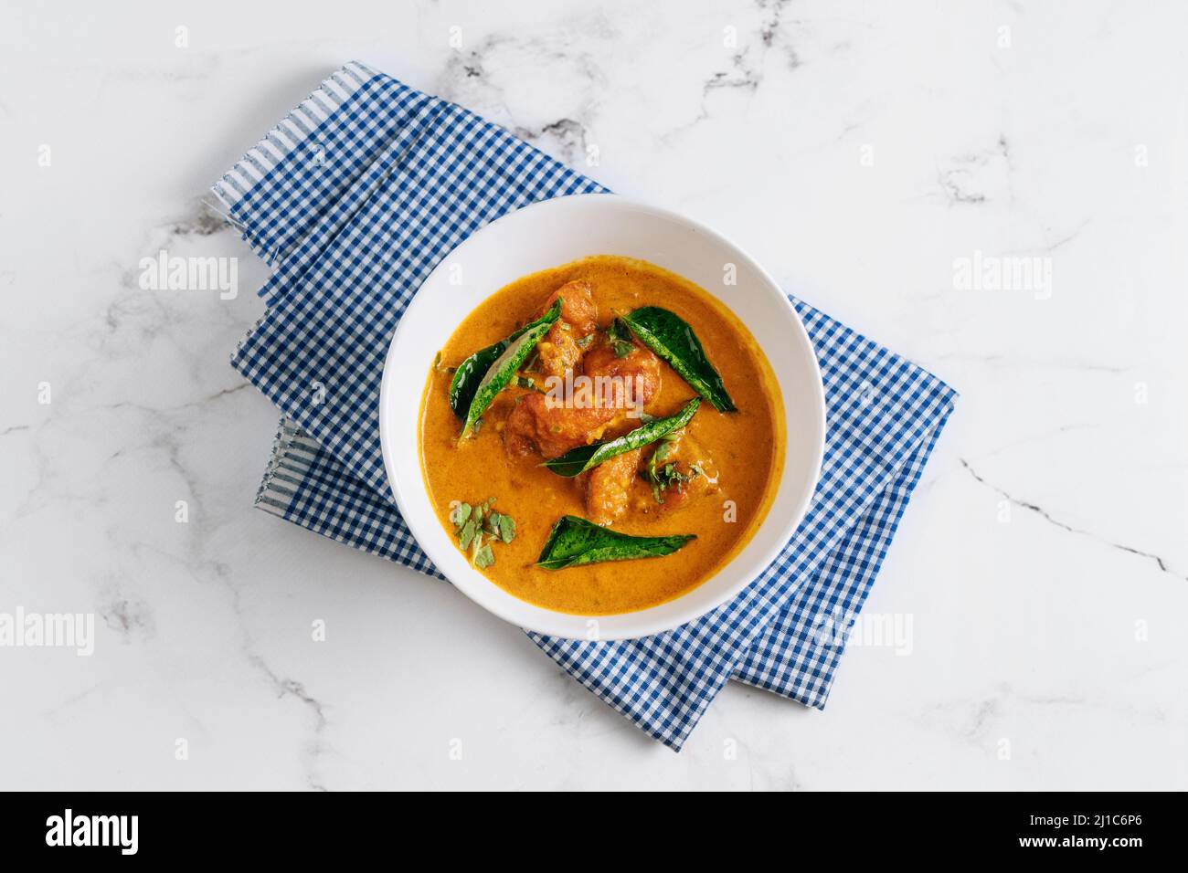 Goan Fish Curry Masala in einem Gericht isoliert auf Serviette Seitenansicht auf grauem Hintergrund berühmten indischen und pakistanischen Essen Stockfoto
