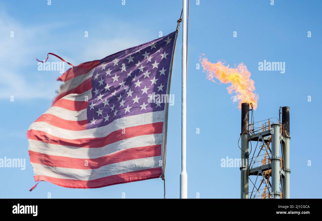 USA-Flagge mit Kamin der Gasanlage. Energiekrise, Russland Ukraine Konflikt, Krieg Großbritannien, Europa Gasversorgung, Lebenshaltungskrise Stockfoto