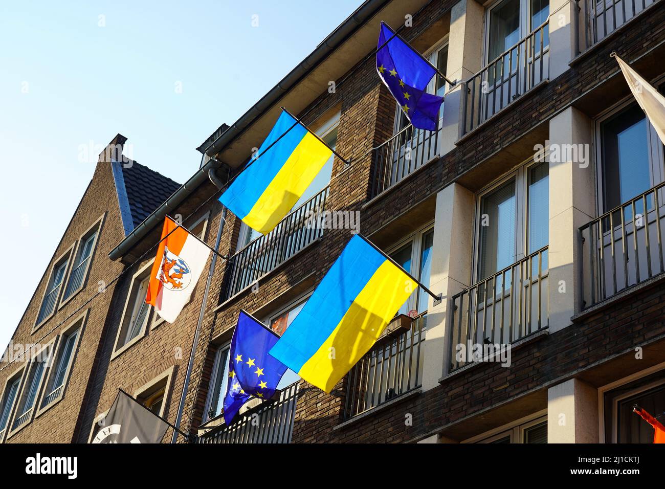 Verschiedene lokale und internationale Flaggen (Düsseldorfer Flagge, EU-Flagge, Ukraine-Flagge) vor einem Restaurant in der Düsseldorfer Altstadt. Stockfoto