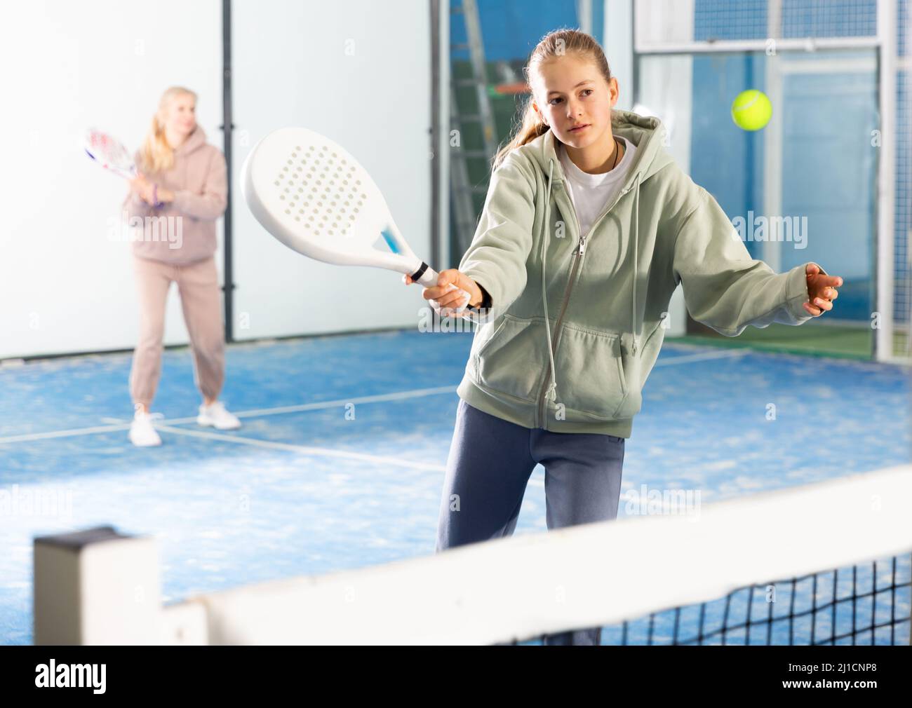 Aktives Teenager-Mädchen, das Padel auf dem Tennisplatz spielt Stockfoto