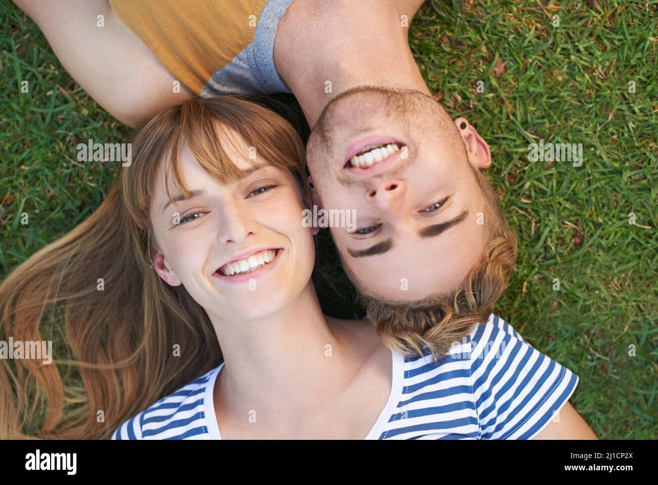Entspannen im Park. Porträt eines glücklichen jungen Paares, das im Park liegt. Stockfoto