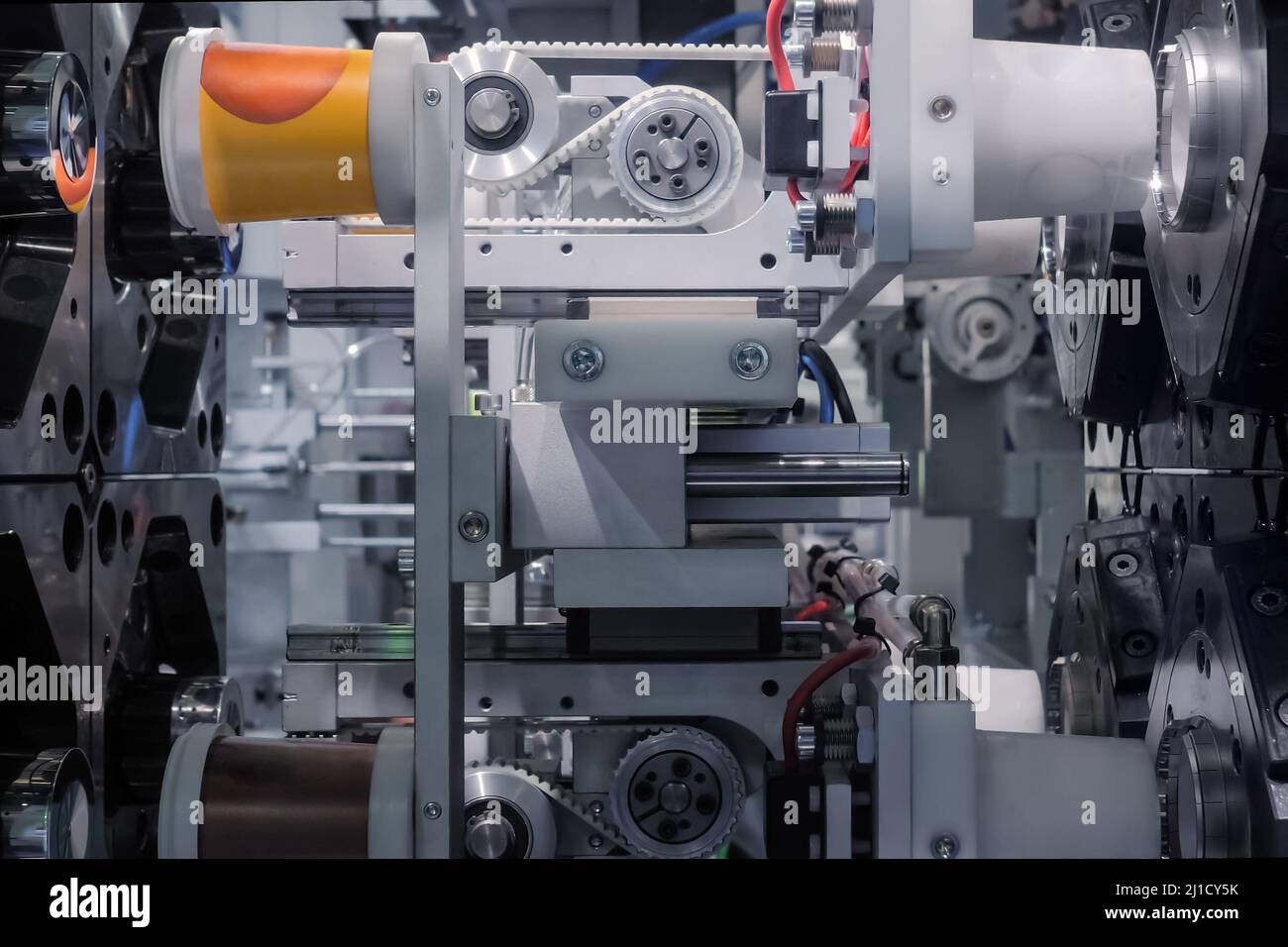 Spritzgießmaschine während der Arbeit: Produktion von leeren Kunststoffbechern Stockfoto