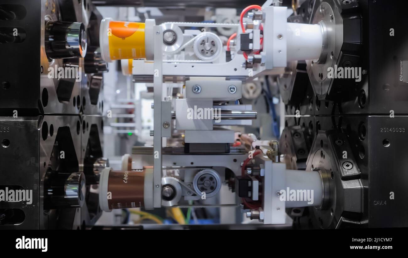 Spritzgießmaschine während der Arbeit: Produktion von leeren Kunststoffbechern Stockfoto