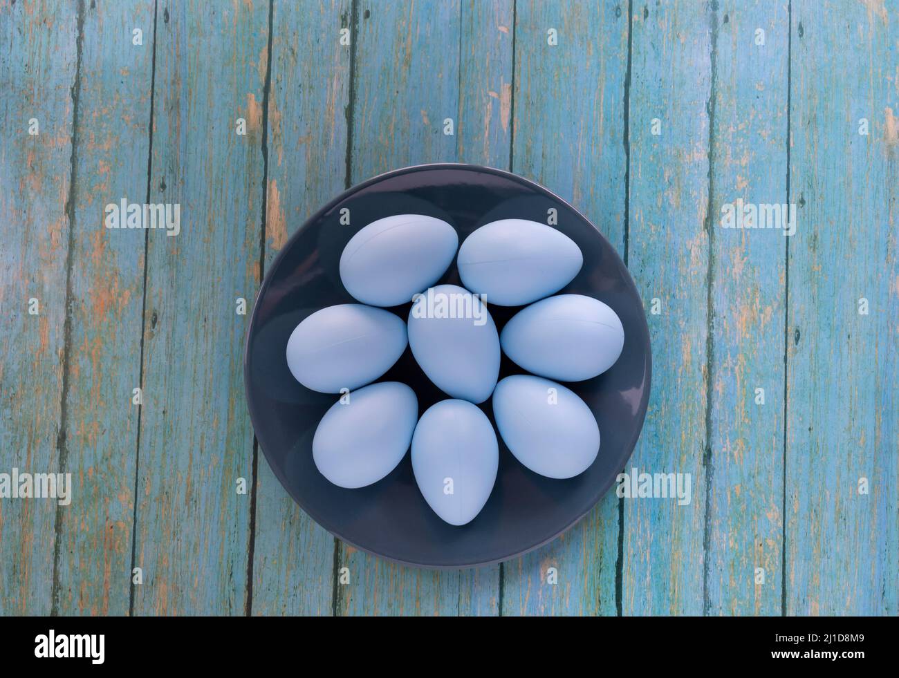 Konzept der Karwoche mit bunten Eiern auf Holzhintergrund. Osterkonzept. Stockfoto