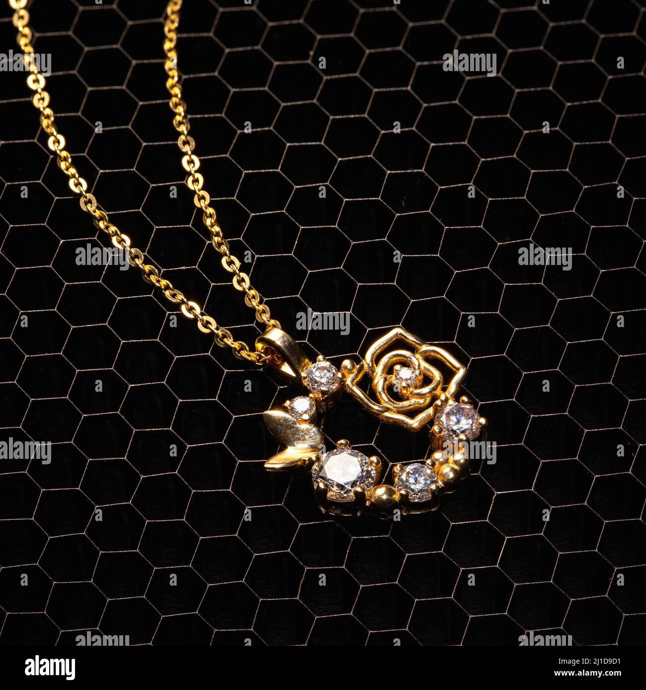 Eine bezaubernde Kollektion von von der Natur inspirierten goldenen Halsketten mit Bienen, Rosen und Edelsteinen – mit Eleganz und Charme gefertigt Stockfoto