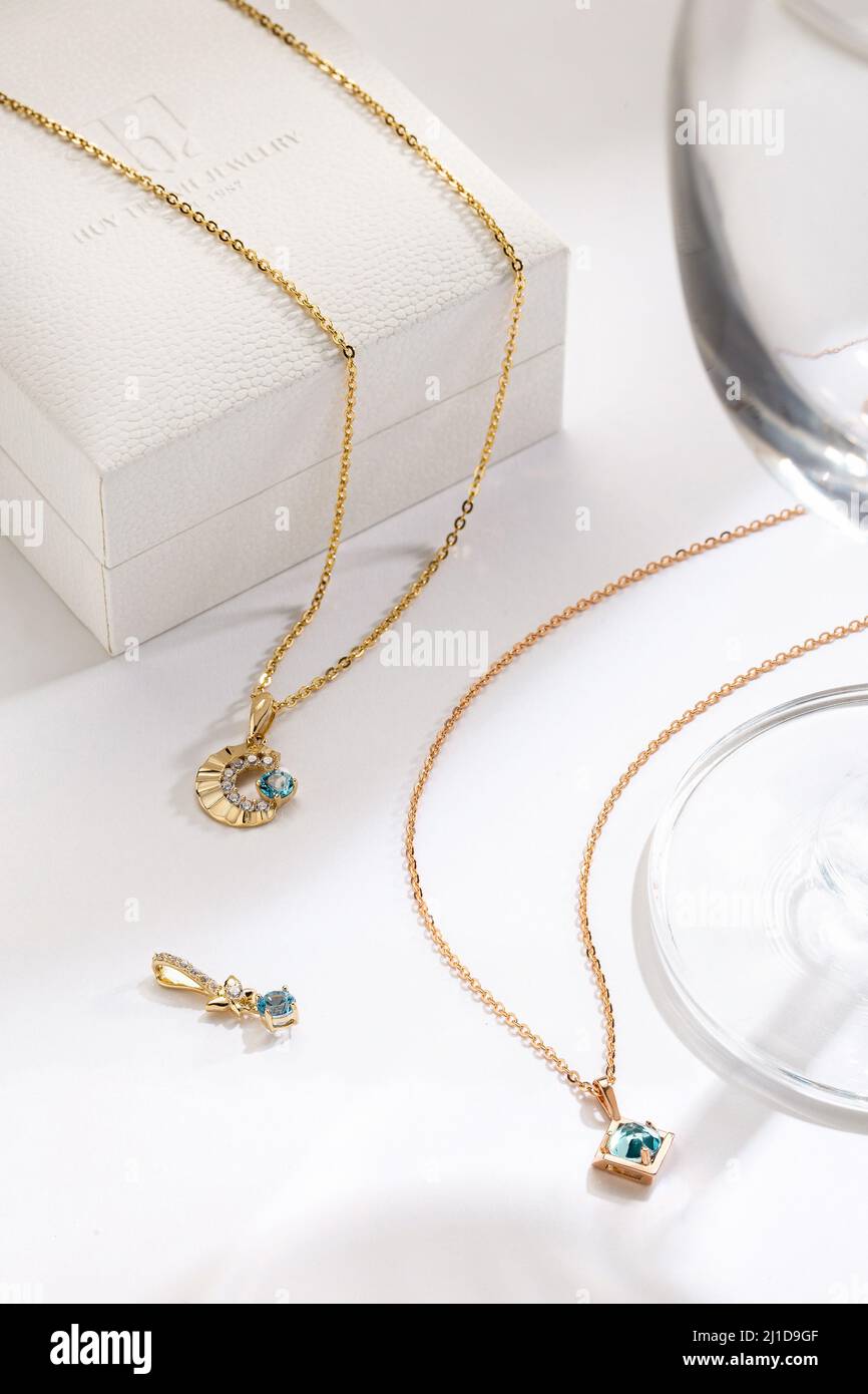 Schicke goldene Halsketten mit türkisfarbenen Edelsteinanhängern, die einen frischen, eleganten Touch bieten, perfekt für tägliche Kleidung oder Geschenke. Stockfoto