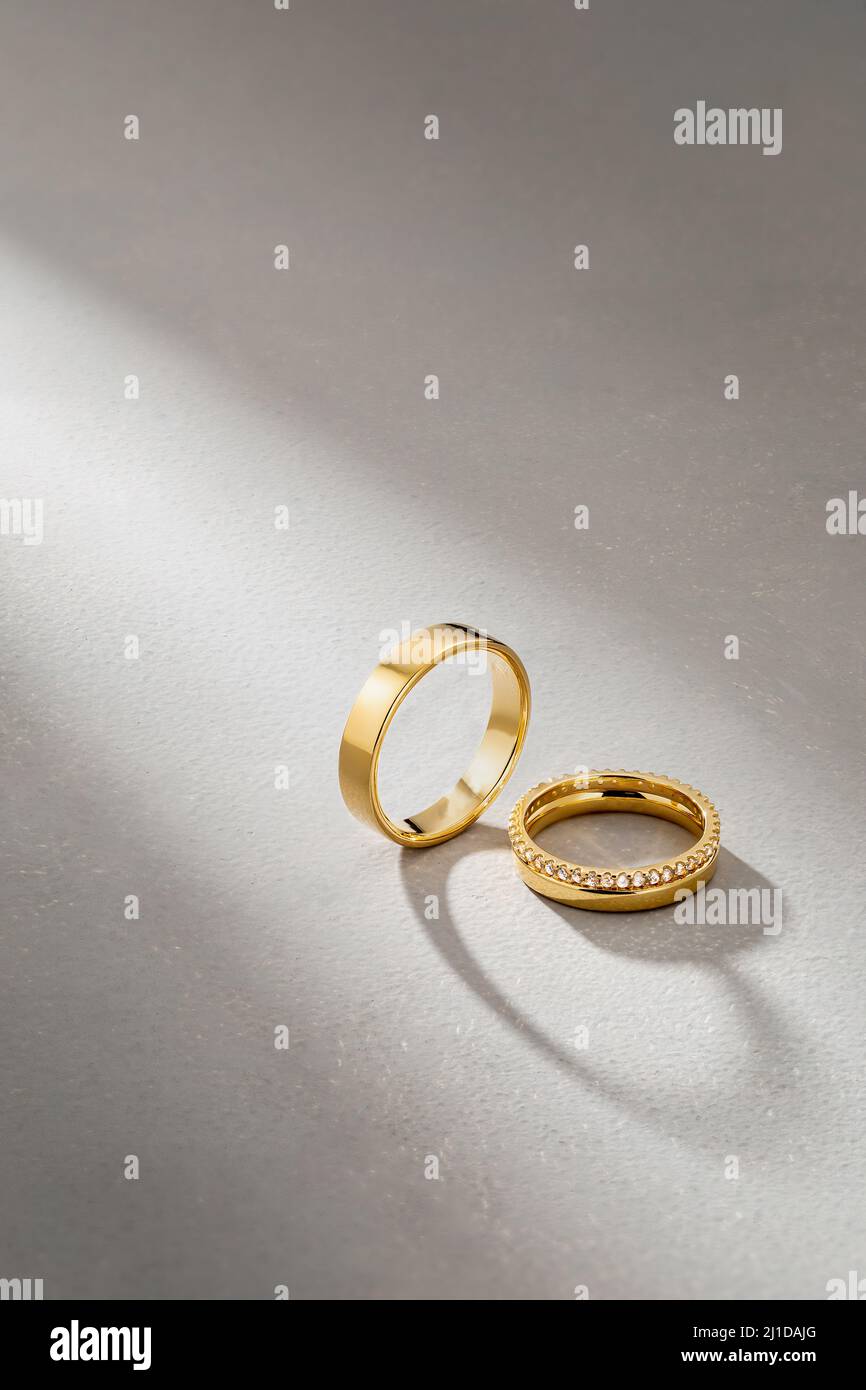 Ein paar Eheringe mit schlichtem Design auf grauem Hintergrund Stockfoto
