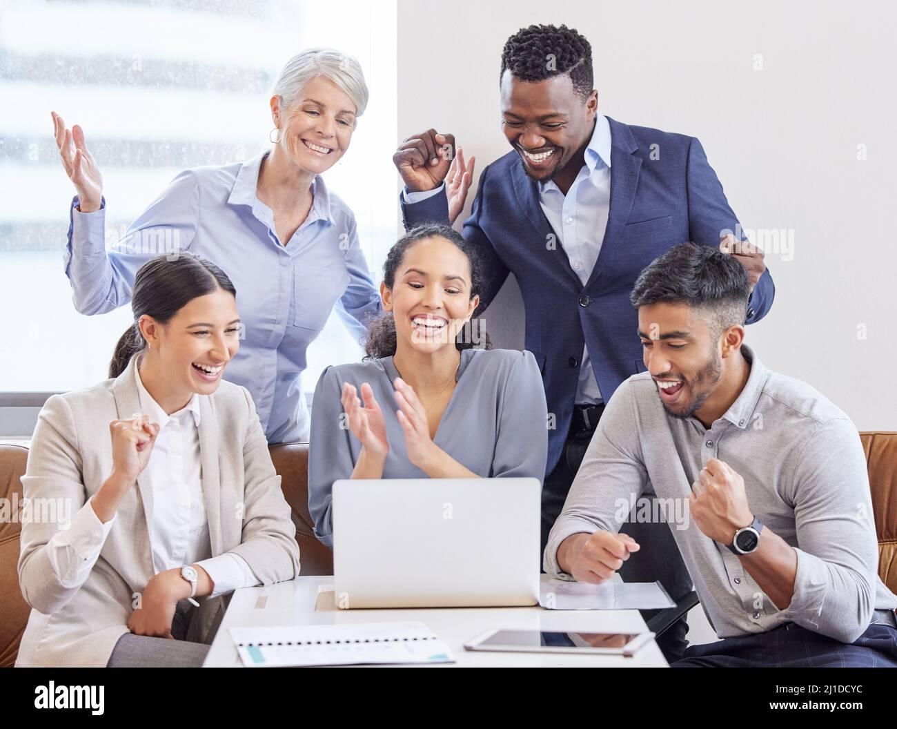 Selbstständiges Arbeiten auf ein Ziel hin. Aufnahme einer Gruppe von Kollegen, die in einem Büro jubeln. Stockfoto