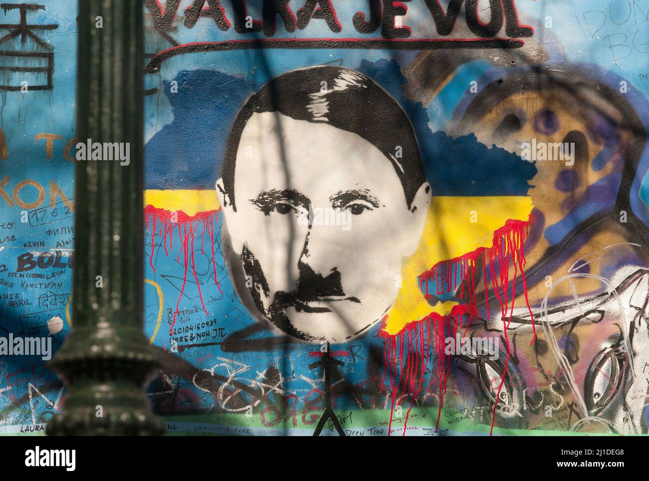 23. März 2022, Tschechische Republik, Prag: Auf der sogenannten John-Lennon-Mauer in Prag hat ein Unbekannter den russischen Präsidenten Wladimir Putin angesichts des Ukraine-Krieges als Adolf Hitler dargestellt. Darüber, am 23. März 2022, steht in tschechischer Sprache der Slogan "valka je vul" - wörtlich: "Krieg ist ein Hornhund". Was damit gemeint ist, ist, dass Krieg Unsinn ist. Die Lennon-Mauer auf der Prager Kleinseite ist seit dem Jahr 1980s mit sich ständig ändernden politischen Botschaften eingeschrieben. Es erinnert an den Beatles-Sänger John Lennon, einer der Ikonen der Friedensbewegung. (Um dpa 'gibt es Parallelen zwischen Putin und Hitler? Stockfoto