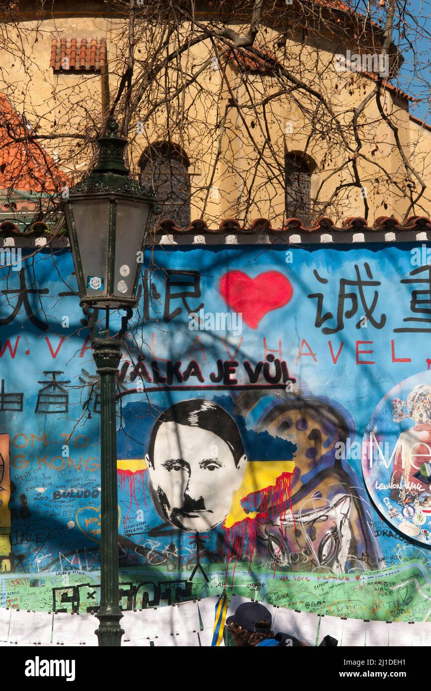 23. März 2022, Tschechische Republik, Prag: Auf der sogenannten John-Lennon-Mauer in Prag hat ein Unbekannter den russischen Präsidenten Wladimir Putin angesichts des Ukraine-Krieges als Adolf Hitler dargestellt. Darüber, am 23. März 2022, steht in tschechischer Sprache der Slogan "valka je vul" - wörtlich: "Krieg ist ein Hornhund". Was damit gemeint ist, ist, dass Krieg Unsinn ist. Die Lennon-Mauer auf der Prager Kleinseite ist seit dem Jahr 1980s mit sich ständig ändernden politischen Botschaften eingeschrieben. Es erinnert an den Beatles-Sänger John Lennon, einer der Ikonen der Friedensbewegung. (Um dpa 'gibt es Parallelen zwischen Putin und Hitler? Stockfoto