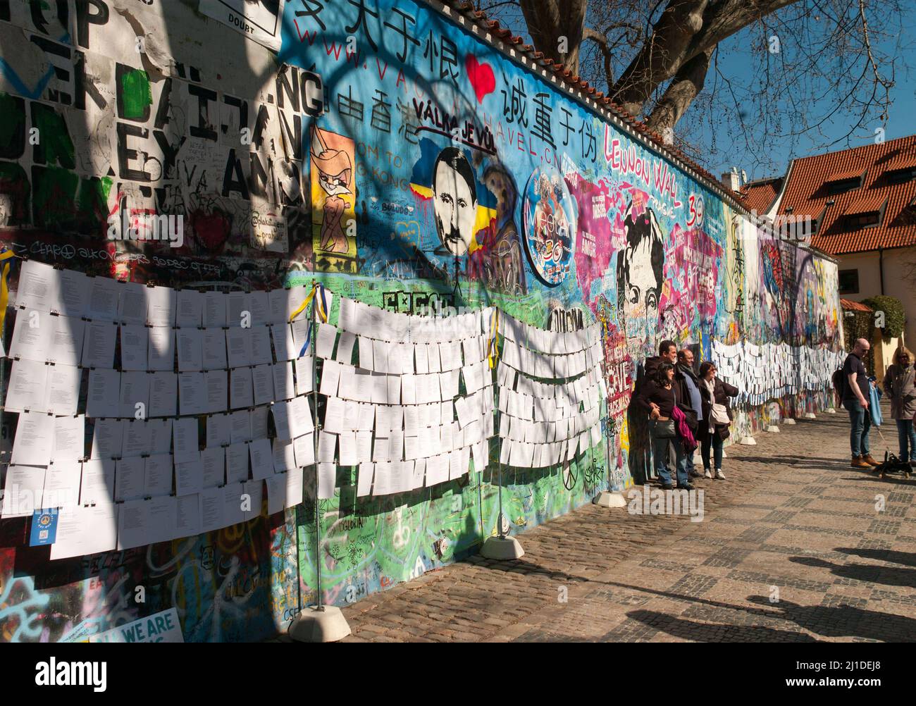 Prag, Tschechische Republik. 23. März 2022. Auf der sogenannten John-Lennon-Mauer in Prag hat ein Unbekannter den russischen Präsidenten Wladimir Putin angesichts des Ukraine-Krieges als Adolf Hitler dargestellt. Darüber auf Tschechisch steht der Slogan „valka je vul“ - wörtlich „Krieg ist ein Hornhund“. Was damit gemeint ist, ist, dass Krieg Unsinn ist. Die Lennon-Mauer auf der Prager Kleinseite ist seit dem Jahr 1980s mit sich ständig ändernden politischen Botschaften eingeschrieben. Es erinnert an den Beatles-Sänger John Lennon, einer der Ikonen der Friedensbewegung. Quelle: Michael Heitmann/dpa/Alamy Live News Stockfoto