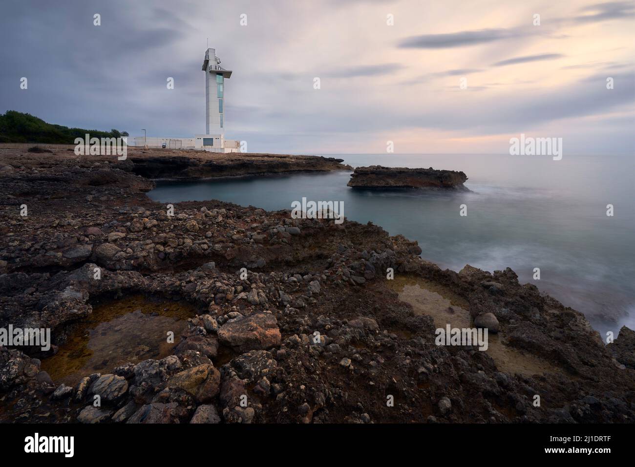 Cala Mundina Leuchtturm bei Sonnenaufgang Stockfoto