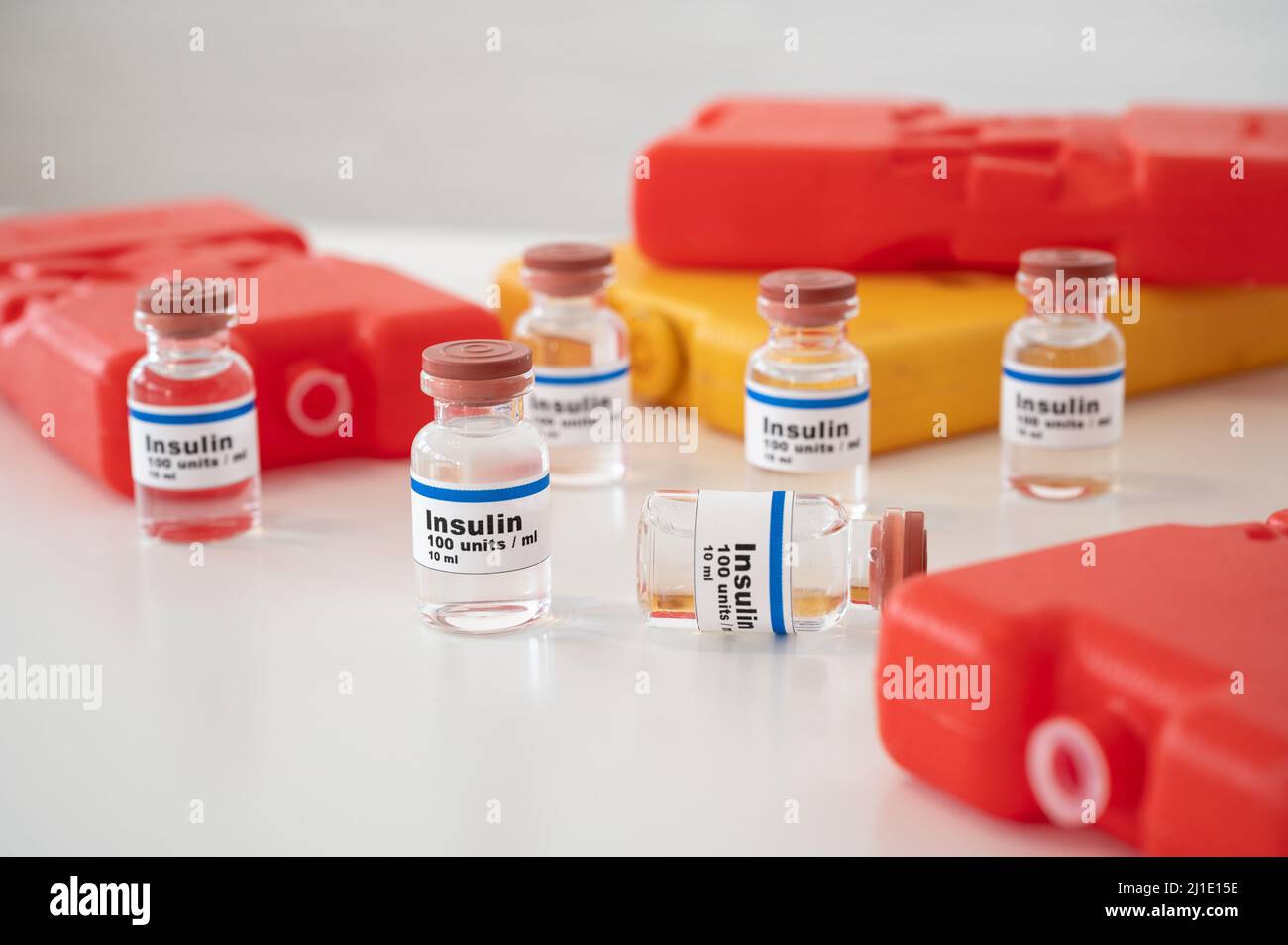 Insulinfläschchen mit kalten Packungen vor weißem Hintergrund: Insulin richtig kühlen und lagern. Stockfoto