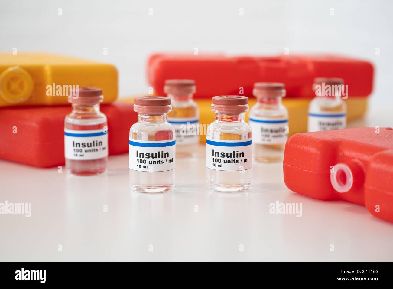 Insulinfläschchen mit kalten Packungen vor weißem Hintergrund: Insulin richtig kühlen und lagern. Stockfoto