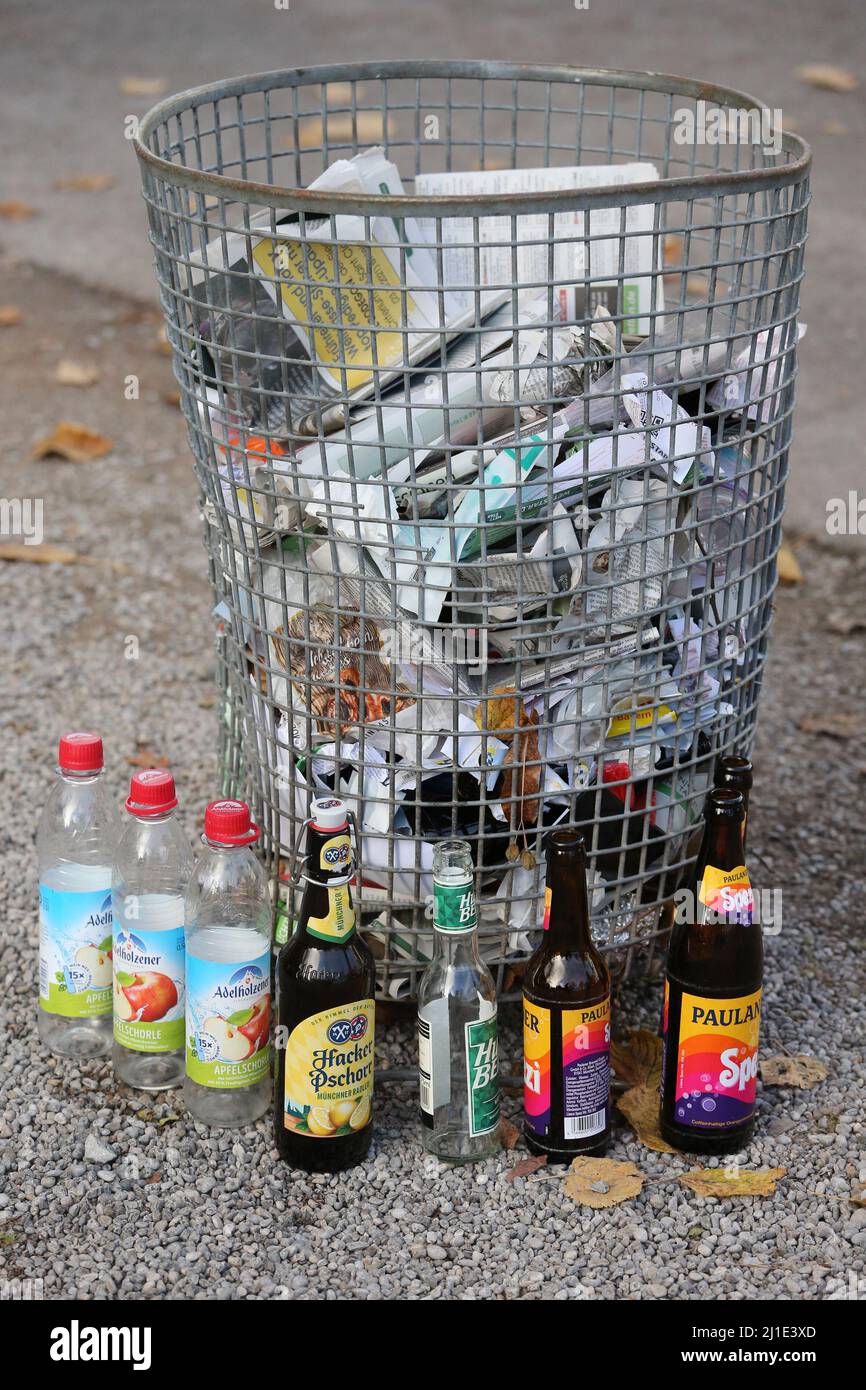 07.11.2021, Deutschland, Bayern, München - leere Getränkeflaschen stehen neben einem papiergefüllten Mülleimer. 00S211107D553CAROEX.JPG [MODELLVERSION: NEIN, PROP Stockfoto
