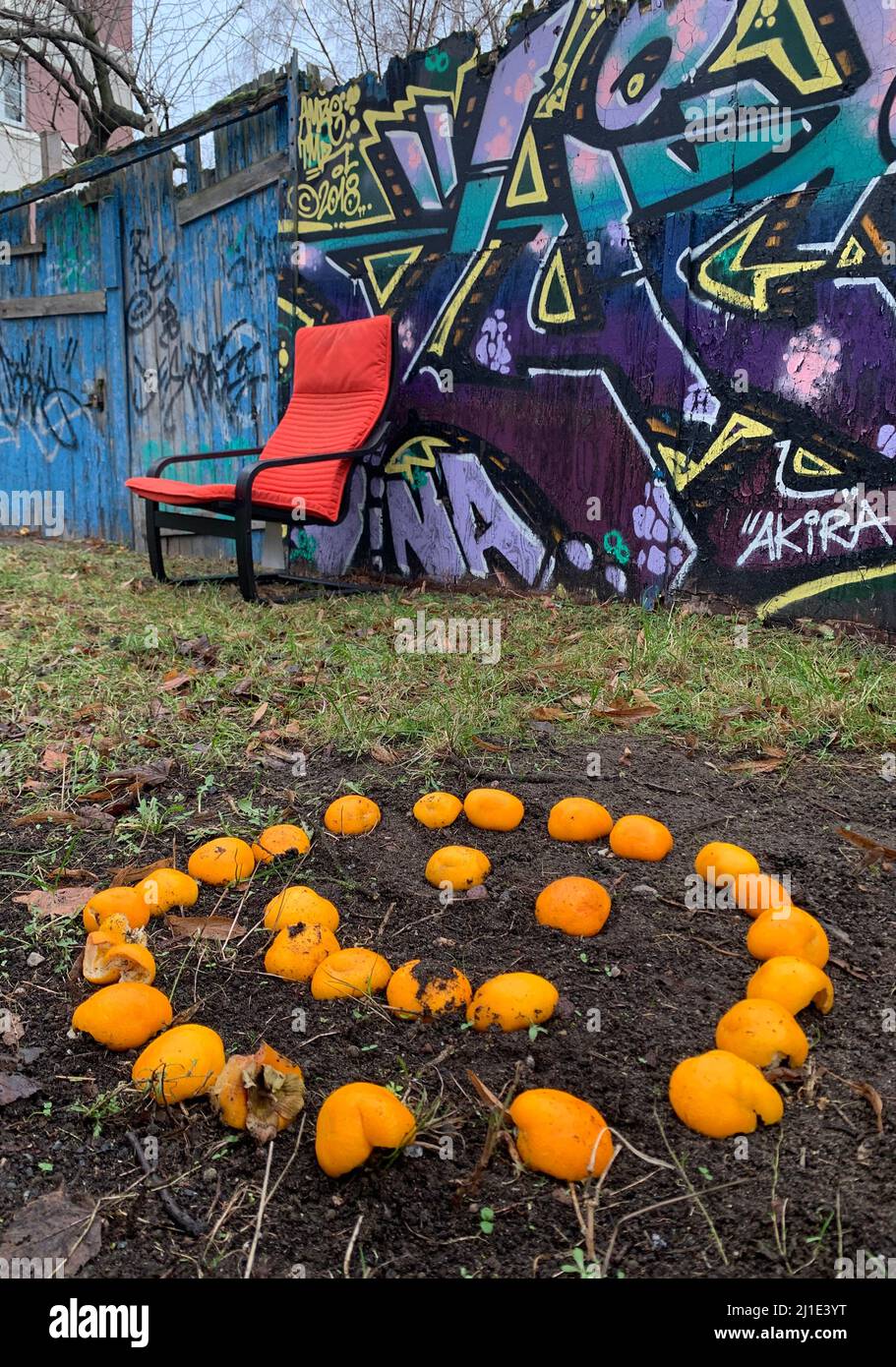 18.12.2021, Deutschland, , Berlin - Smilie aus Orangen vor einer mit Graffiti bedeckten Holzwand. 00S211218D735CAROEX.JPG [MODELLVERSION: NEIN, PR Stockfoto