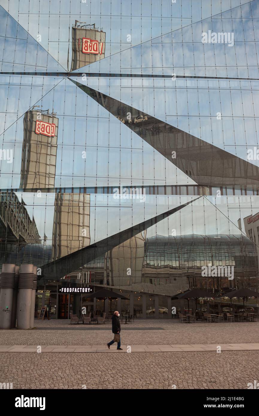 22.01.2022, Deutschland, , Berlin - der Turm des Berliner Hauptbahnhofs mit dem DB-Logo spiegelt sich in der futuristischen Glasfassade des neuen 3XN Cube B wider Stockfoto