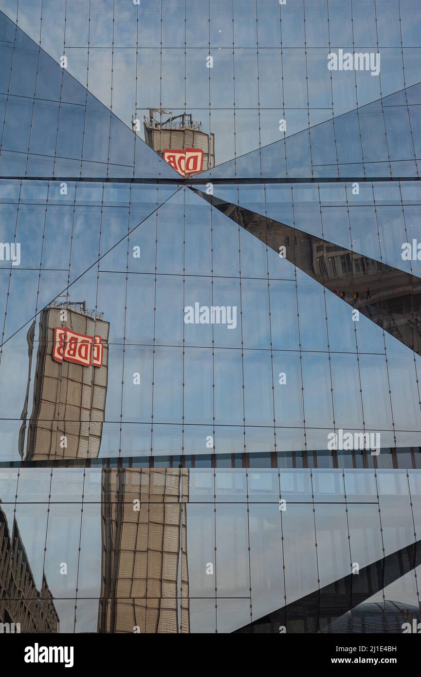 22.01.2022, Deutschland, , Berlin - der Turm des Berliner Hauptbahnhofs mit dem DB-Logo spiegelt sich in der futuristischen Glasfassade des neuen 3XN Cube B wider Stockfoto