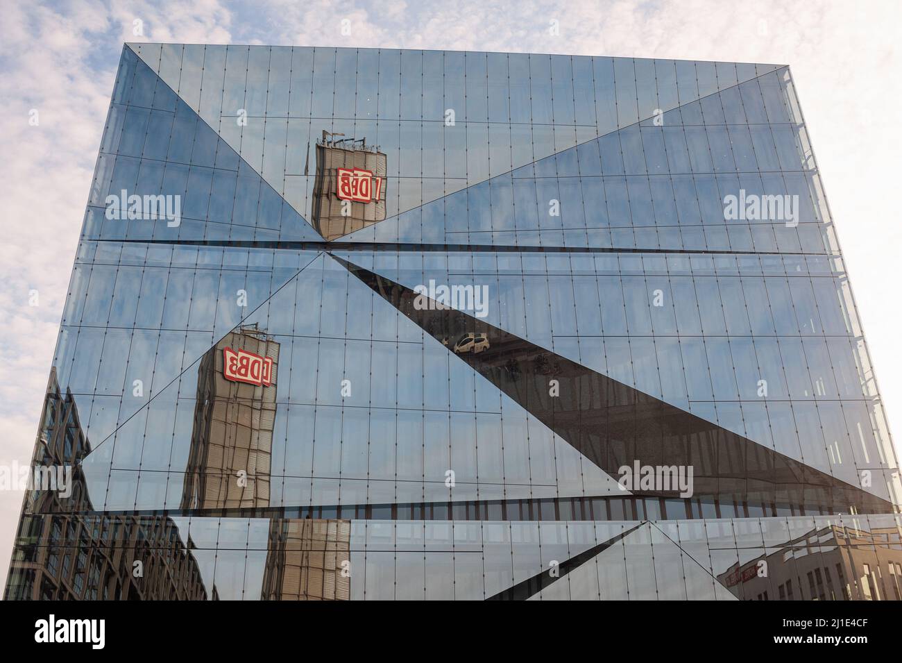 22.01.2022, Deutschland, , Berlin - der Turm des Berliner Hauptbahnhofs mit dem DB-Logo spiegelt sich in der futuristischen Glasfassade des neuen 3XN Cube B wider Stockfoto