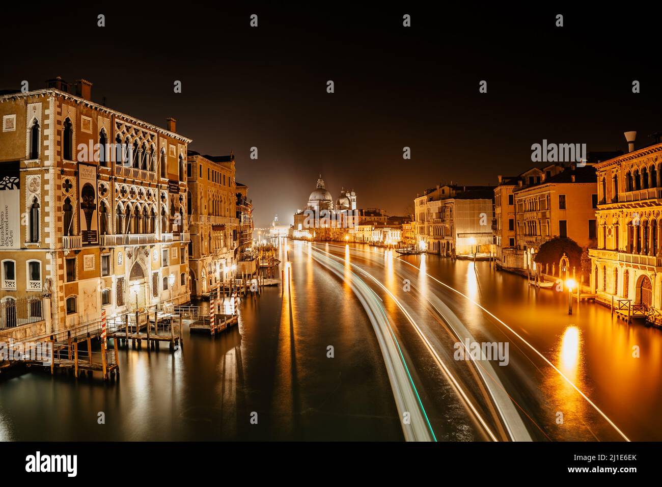 Canale Grande bei Nacht, Venedig, Italien. Typische Bootstransport, venezianischer öffentlicher Wasserbus lange Exposition. Wassertransport. Reise städtische Szene. Beliebt Stockfoto