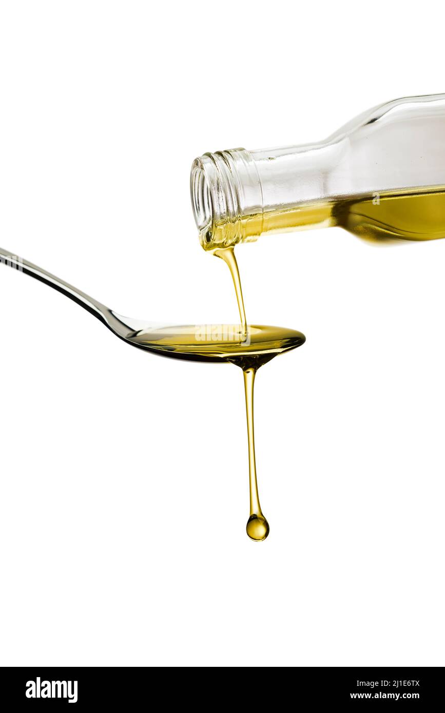 Olivenöl Flasche Gießen Öl auf Löffel, isoliert auf weißem Hintergrund Stockfoto