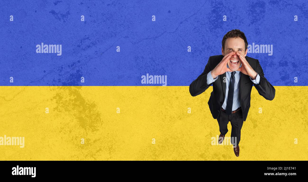 Hochwinkelporträt eines Geschäftsmannes, der über die ukrainische Flagge schreit Stockfoto