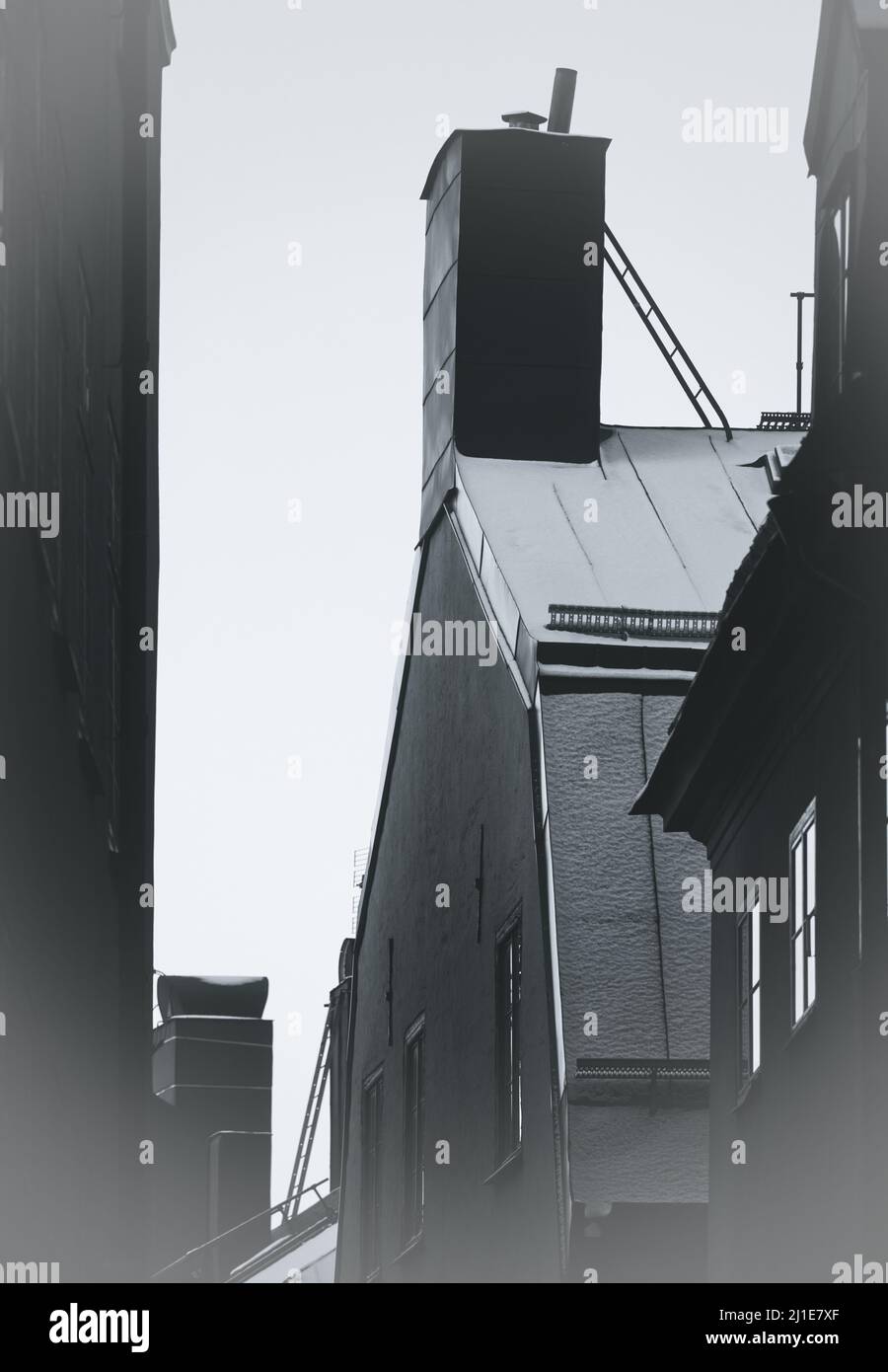 Dachleitern und schneebedeckte Dächer und Kamine, Gamla Stan, Stockholm, Schweden. Konzept von Flucht, Gefahr Stockfoto