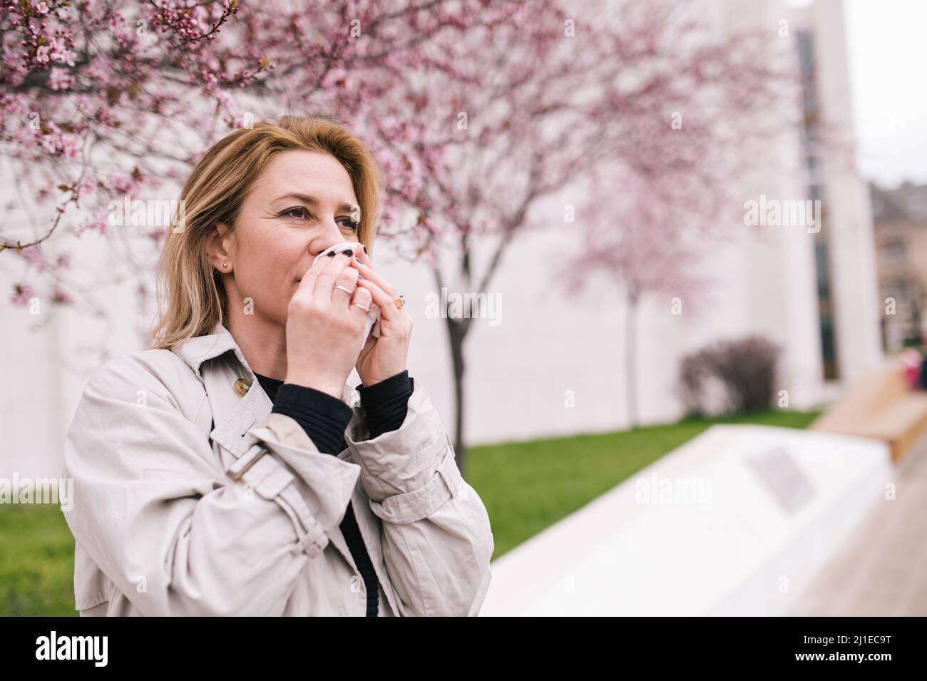 Frau, die ein Niesproblem hat. Auswirkungen von Pollen auf die Gesundheit. Stockfoto