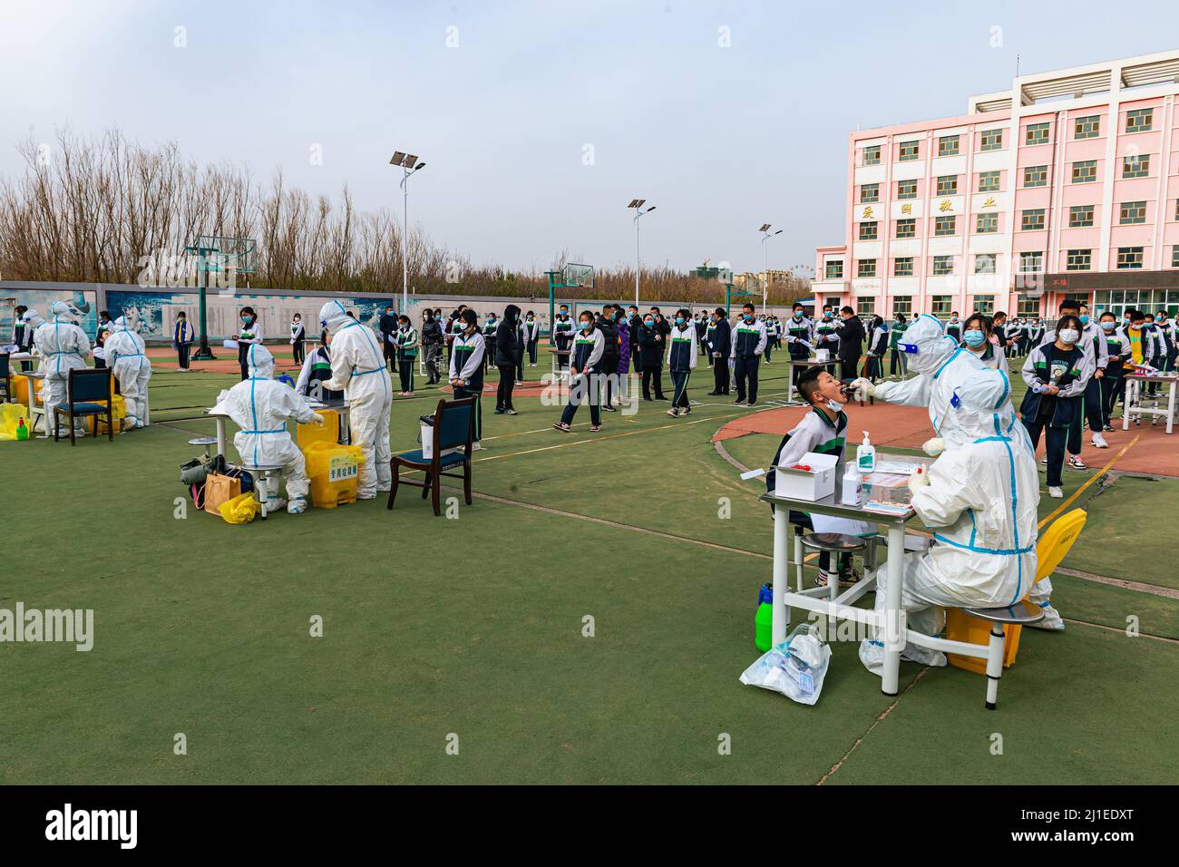 JIUQUAN, CHINA - 24. MÄRZ 2022 - Schüler der Mittelschule nehmen am Nukleinsäuretest in Jiuquan, Provinz Gansu, China, am 24. März 2022 Teil. Stockfoto