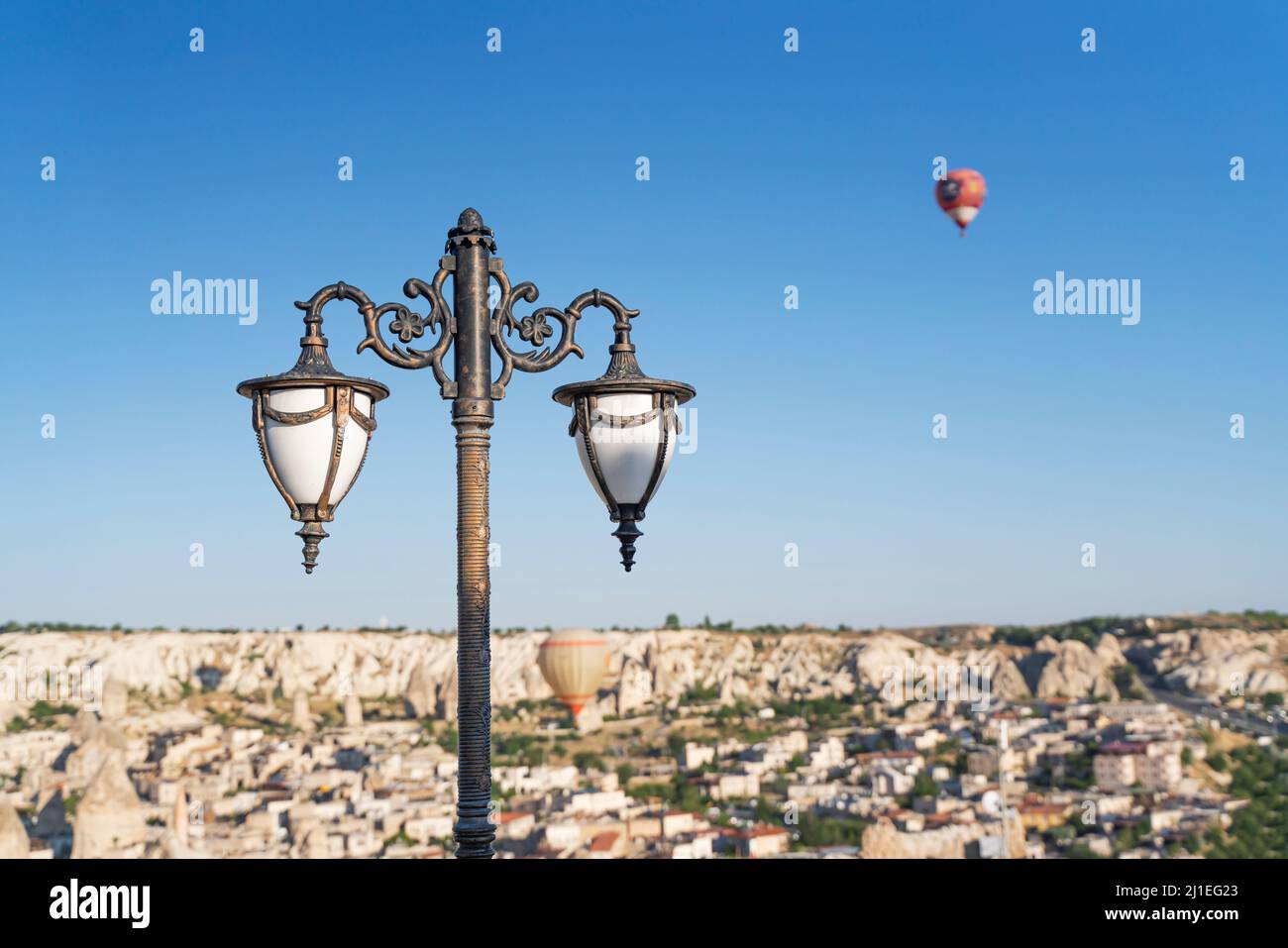 Blick auf eine Straßenlampe gegen einen Heißluftballon am blauen Himmel von kappadokien. Stockfoto