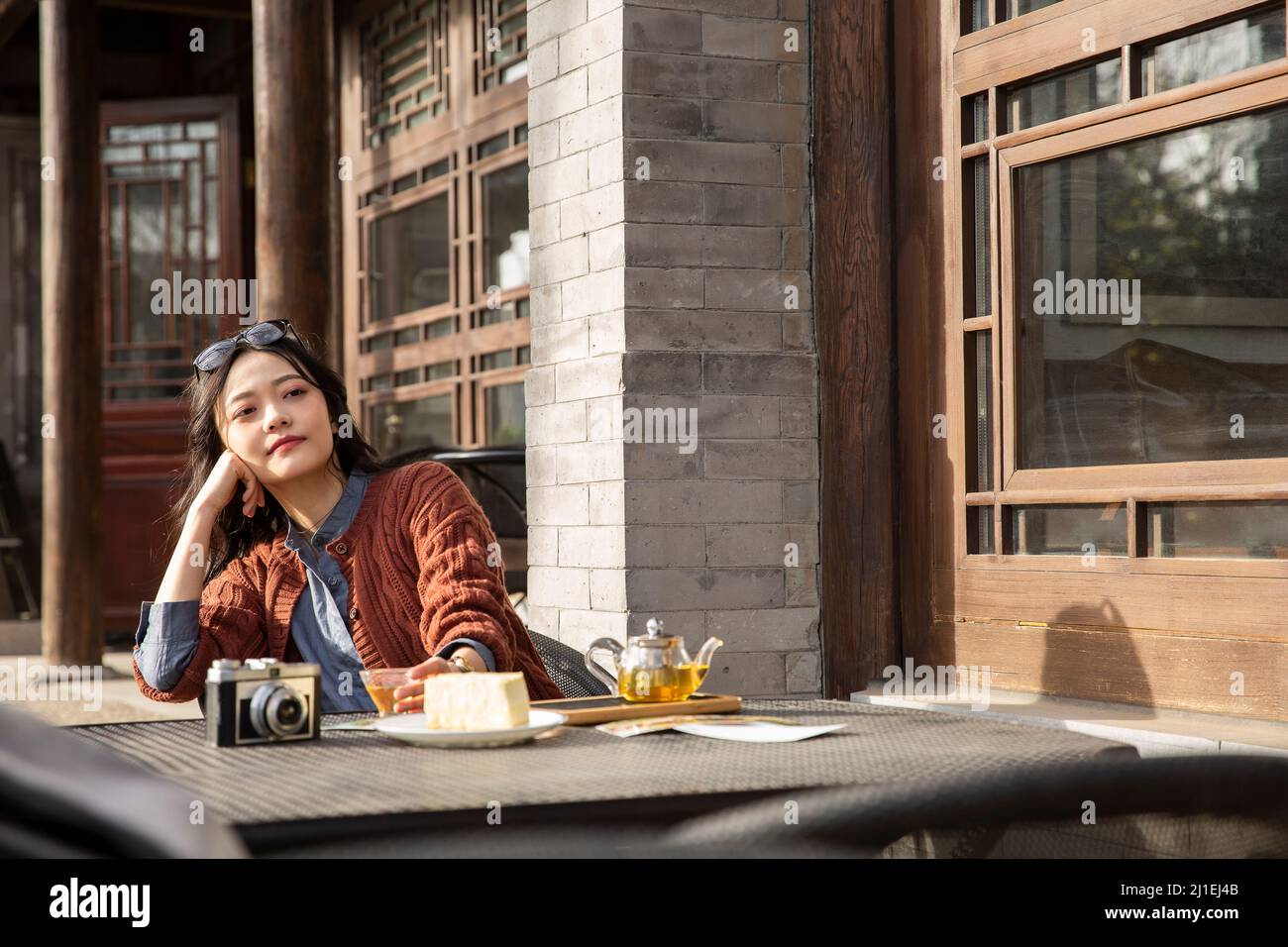 Chinesische Frau mit weißem Kragen genießt das Leben im Bürgersteig-Café - Stock-Foto Stockfoto