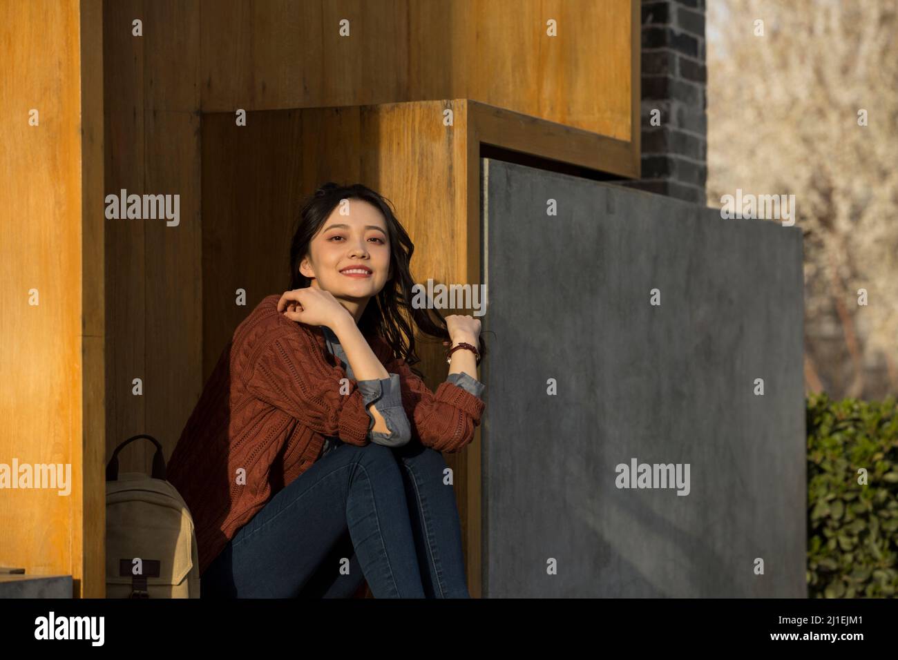 Junges Mädchen sitzt vor einem modernen Buchladen - Stock Foto Stockfoto