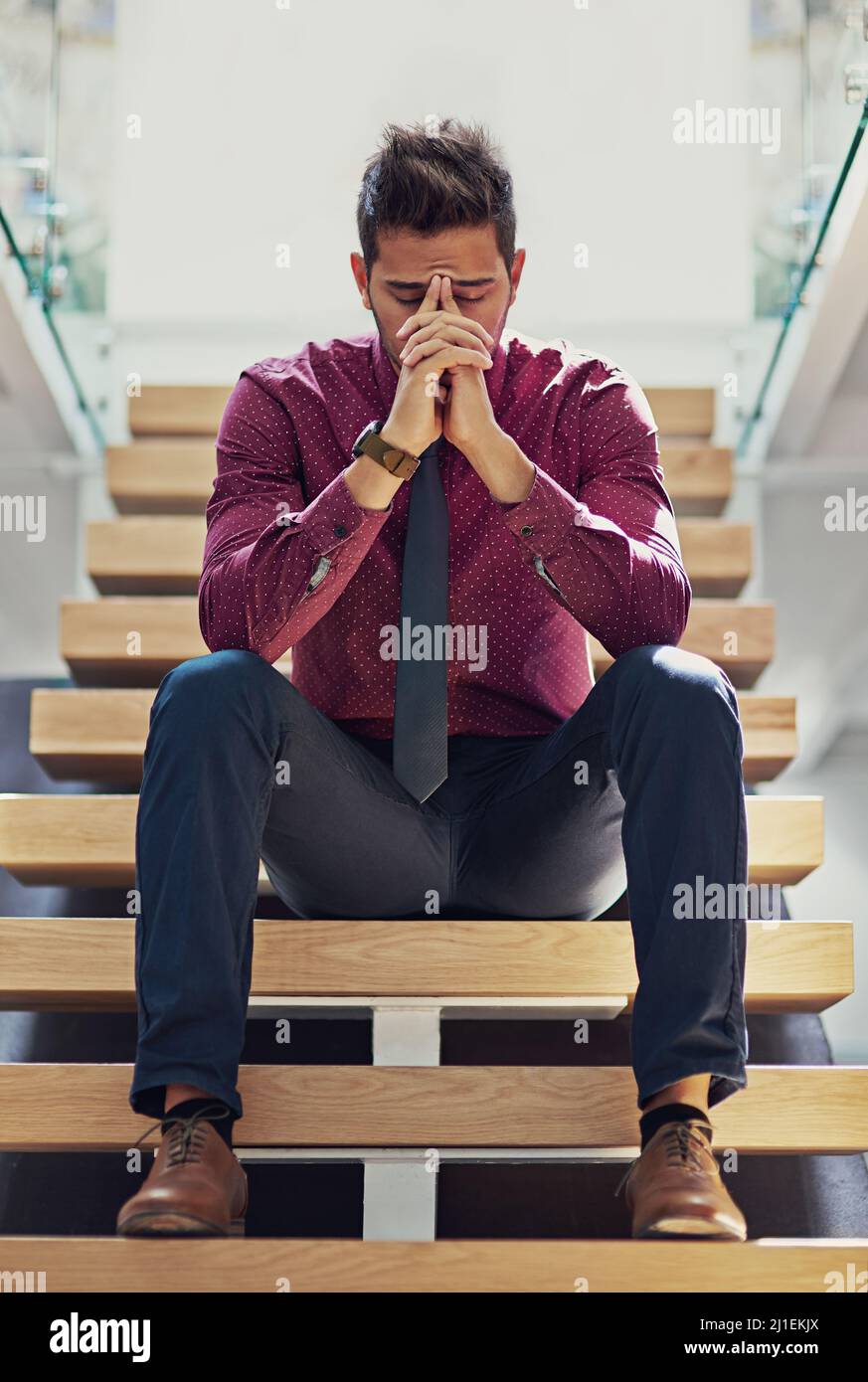 Die Dinge werden besser werden müssen Aufnahme eines jungen Geschäftsmannes, der gestresst auf der Treppe sitzt. Stockfoto
