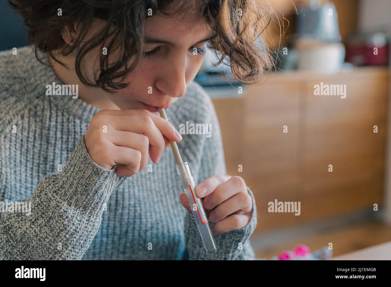 Sammlung von Speicheltest für Coronavirus zu Hause. Teenager-Mädchen führt einen Schnelltest der Speichelprobe auf Vorhandensein von Coronavirus Stockfoto