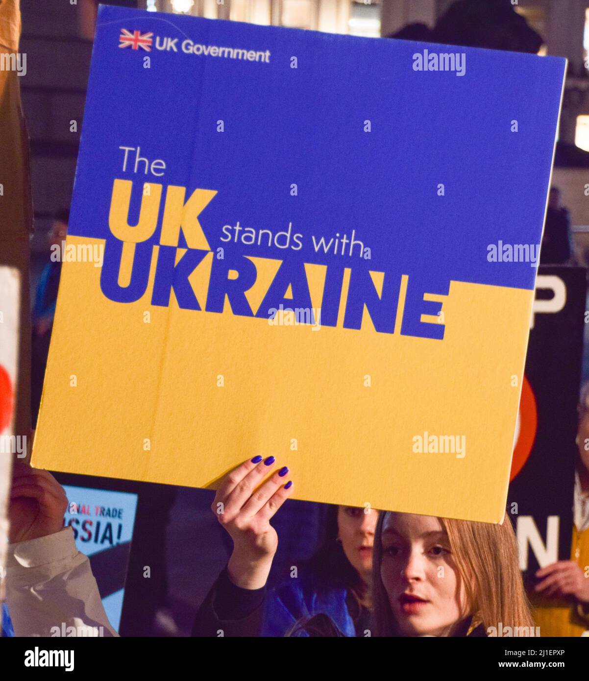 London, Großbritannien. 24.. März 2022. Ein Protestler hält ein Schild „Großbritannien steht mit der Ukraine“. Demonstranten versammelten sich auf dem Trafalgar-Platz in Solidarität mit der Ukraine zum einmonatigen Jahrestag der russischen Invasion. Stockfoto