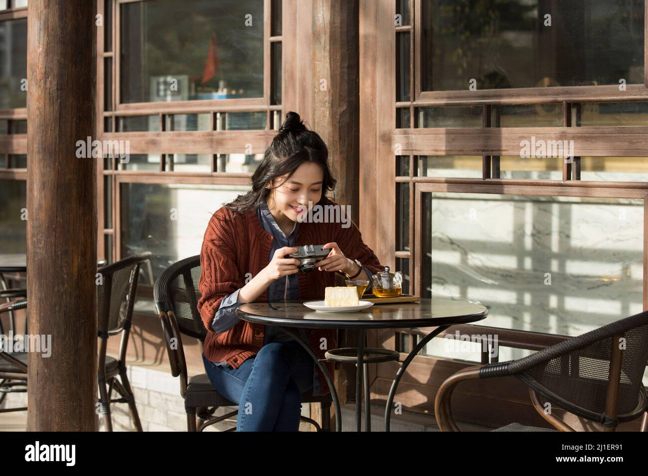 Junge Dame fotografiert im Straßencafé - Stock Foto Stockfoto