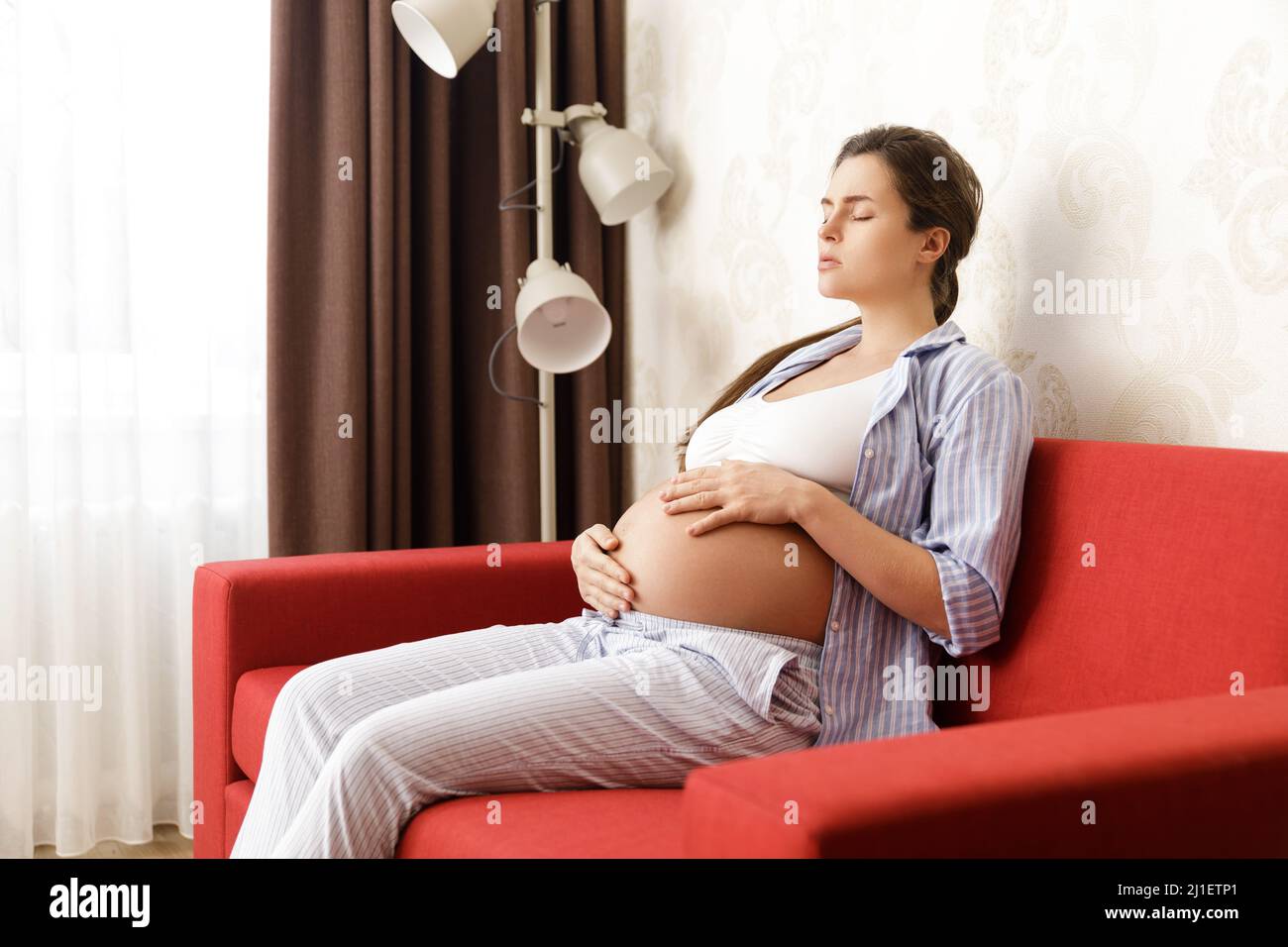 Schwanger Frau zu Hause. Verschiedene gesundheitliche Probleme während der Schwangerschaft. Stockfoto