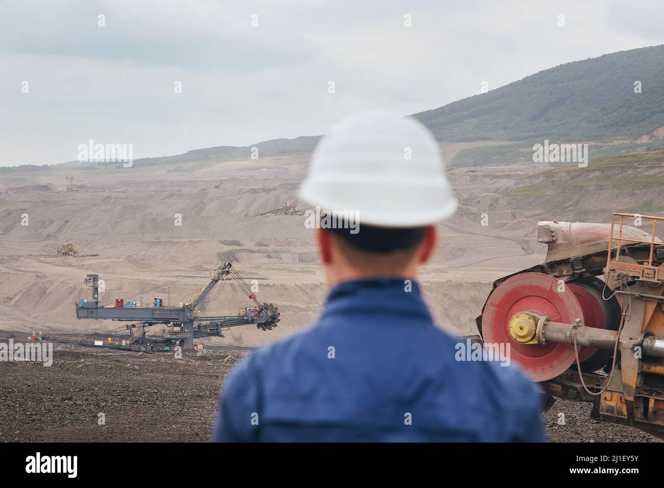Kohlebergbau in Surface Mine. Bergmann beim Blick auf den riesigen Bagger. Stockfoto