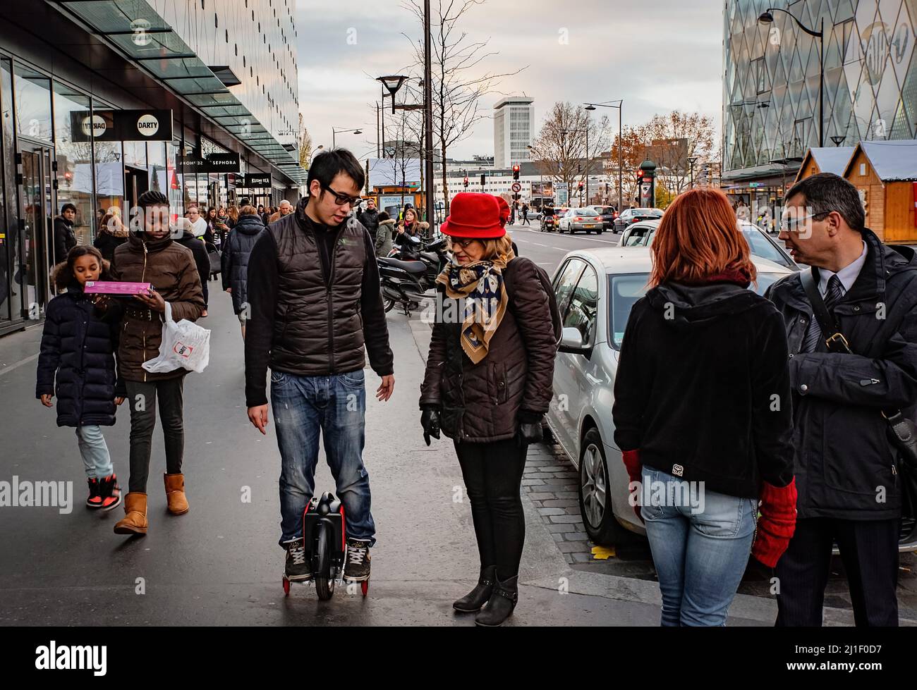 Der junge Mann, der auf der belebten Straße voller Menschen einradeln kann. Paris, Frankreich. Stockfoto