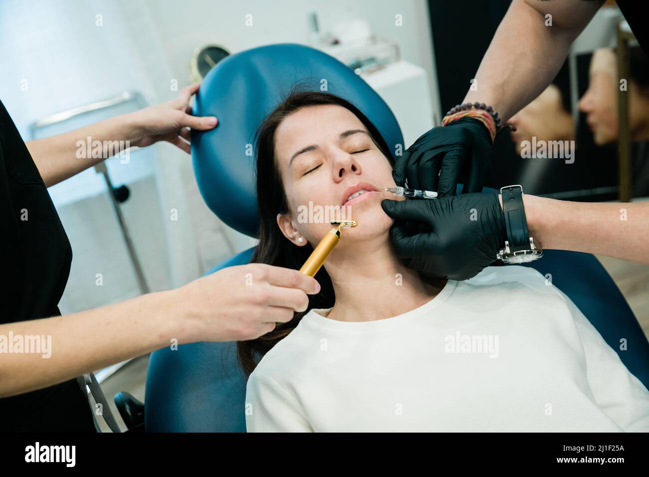 Eine Frau, die von medizinischem Fachpersonal Botulinumtoxin oder Füllstoffe an ihren Wangen und im Mundbereich bekommt Stockfoto