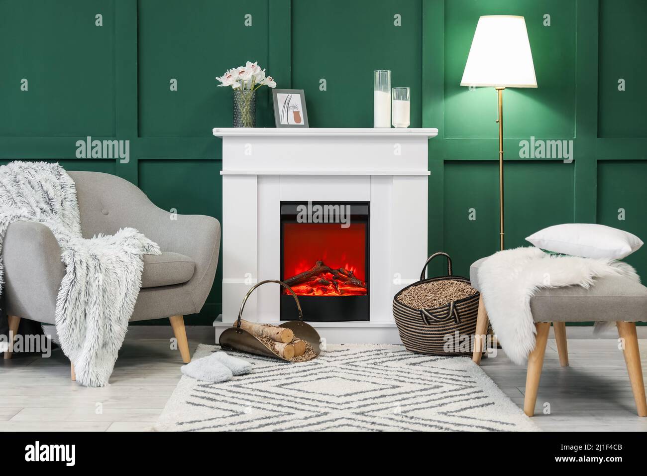 Interieur des stilvollen Wohnzimmers mit Kaminholz, Kaminholz und Sessel Stockfoto