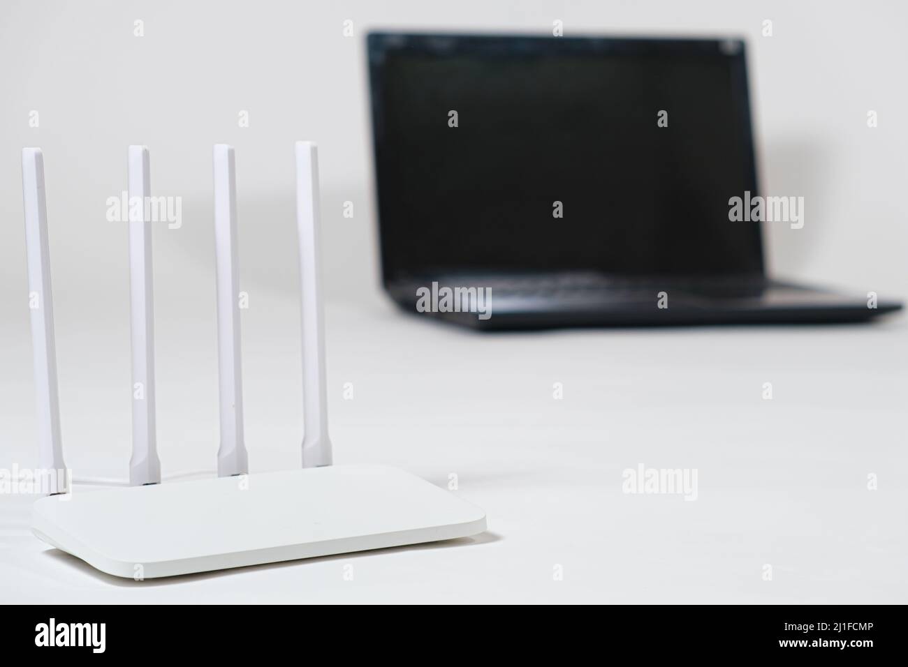 Laptop und wi-Fi-Router auf weißem Hintergrund. Internetverbindung. Stockfoto